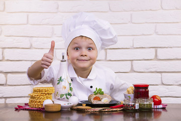 funny boy chef prepares meat rolls