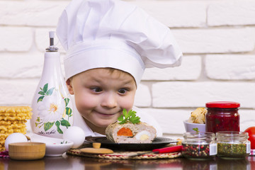 funny boy chef prepares meat rolls