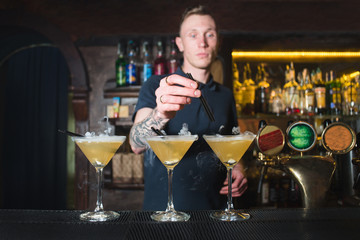 The barman has created beautiful alcoholic cocktails in a nightclub. The barman makes a beautiful cocktail.