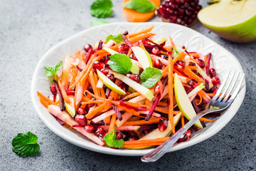 Vegan carrot beetroot apple salad with mint cumin vinaigrette on stone background. Selective focus, copy space.