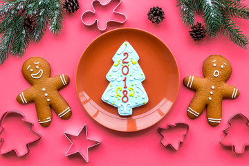 Cookies for New Year. Gingerbread man and spruce with lettering 2018 near spruce branch on pink background top view