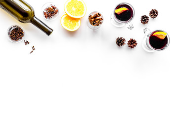 Ingredients for mulled wine. Wine in bottle, spices cinnamon and badian, citrus fruits on white background top view copyspace