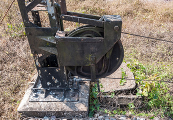 Old steel pulley with the metal wire of the traffic signal pole.