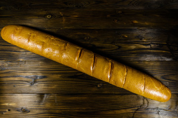 French white baguette on a wooden table. Top view