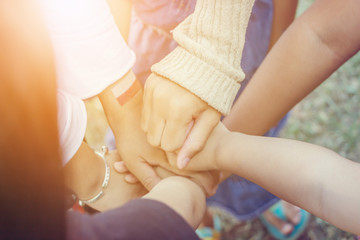 Obraz na płótnie Canvas Success Teamwork Concept, Group of children joining hands blurred background