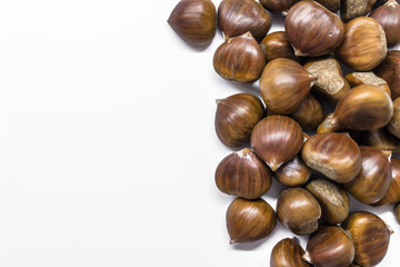 Chestnuts on a blank (white) background. Pile of fresh chestnuts ready to roast shot over white background