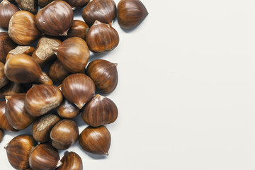 Chestnuts on a blank (white) background. Chestnuts arranged on left side with copy space.