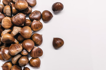 Chestnuts on a blank (white) background. Chestnuts arranged on left side with copy space.
