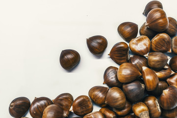 Chestnuts on a blank (white) background. Pile of fresh chestnuts ready to roast shot over white background