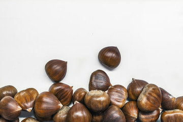 Chestnuts on a blank (white) background. Pile of fresh chestnuts ready to roast shot over white background