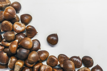 Chestnuts on a blank (white) background. Pile of fresh chestnuts ready to roast shot over white background