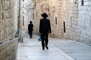 Two unrecognized religious jewish men walking down the street in Old City of Jerusalem.