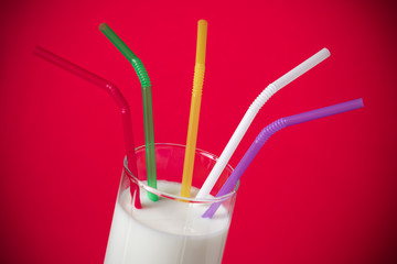 Milk in glass with colorful straws