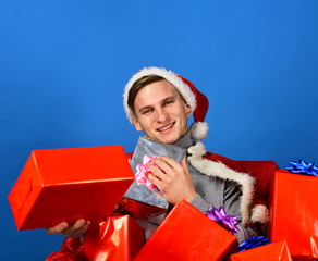 Man holds xmas presents. Santa with gifts on blue background