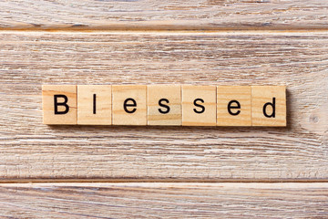 Blessed word written on wood block. Blessed text on table, concept