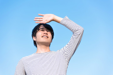 若い男性・日差しが眩しい