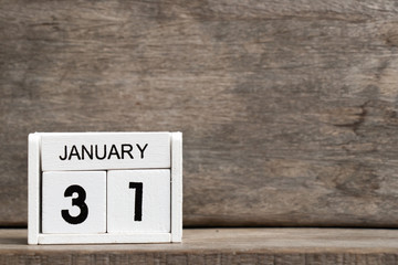 White block calendar present date 31 and month January on wood background