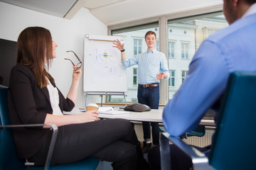 Obraz premium Smiling Businessman Gesturing While Giving Presentation To Colle