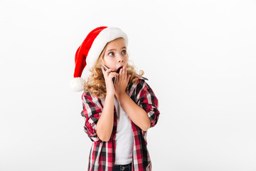 Portrait of a surprised little girl dressed in christmas hat