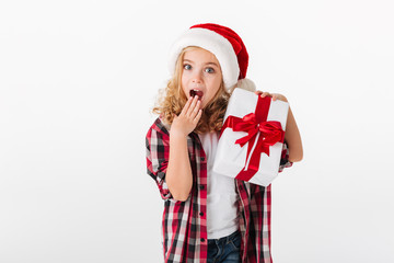 Portrait of an astonished little girl holding gift box