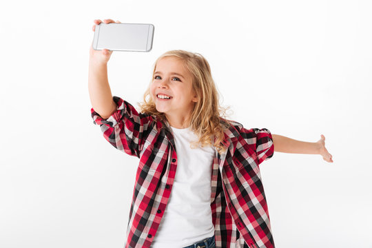 Portrait of an excited little girl taking a selfie