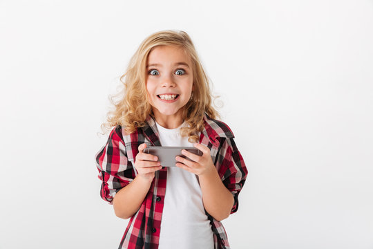 Portrait of an excited little girl holding mobile phone