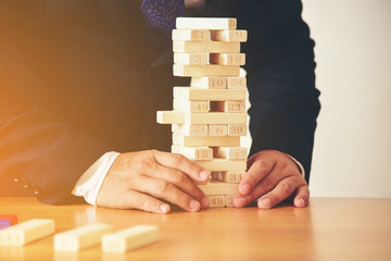 Businessmen put a hand on the dominoes