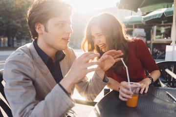 young couple lovers outdoor sitting bar back light having fun - love, relationship, getting away from it all concept