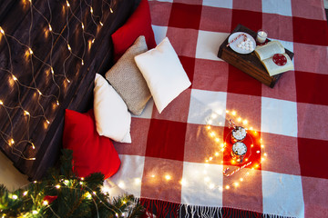 Chill and cozy evening at home in merry christmas evening in red carpet. New year with reading book, candle, cocoa. marshmallow, cup, cockie, candy cane, pillow, indoor
