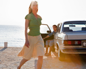 Couple with oldtimer by sea