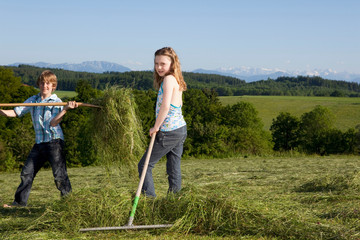Boy and girl raking lawn