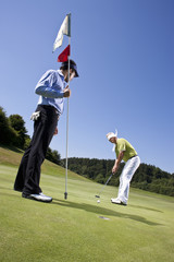 Blindfolded golfing man and Caddy