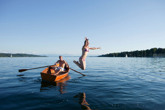 Young Woman Jumping Off A Row Boat