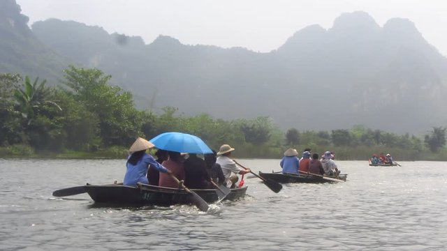 Traditional Rowing Boats Between Karst Mountains
