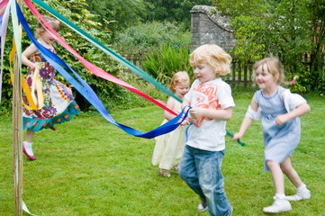 Children dancing round a maypole - obrazy, fototapety, plakaty