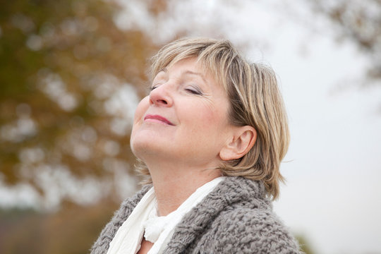 Older Woman Relaxing Outdoors In Autumn