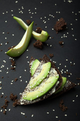 Fresh toast of avocado and black diet bread. A healthy organic and vegetarian breakfast.