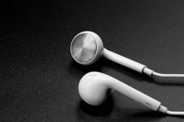 white headphones on black texture with shadow
