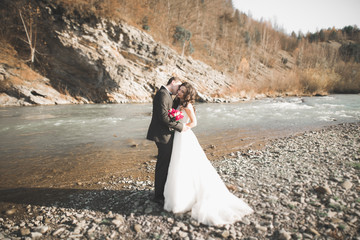 Wedding couple, groom and bride hugging, outdoor near river