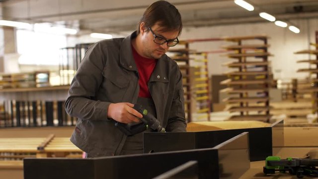 assembler with screwdriver making furniture