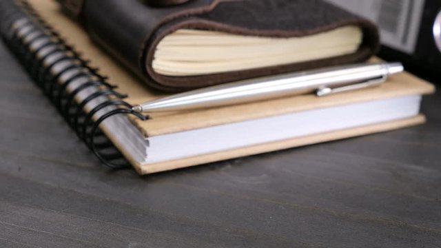 Dolly close in parallax footage on vintage type notebook on a wooden table. Retro type diary