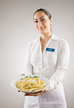 Woman In Nametag Holding Plate Of Pasta