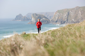 Boy running on cliffs over beach