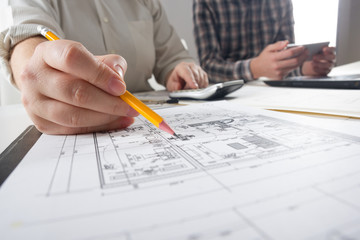Architects working on blueprint, real estate project. Architect workplace - architectural project, blueprints, ruler, calculator, laptop and divider compass. Construction concept. Engineering tools.