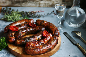baked homemade sausages on wooden Board with spices on a concrete background