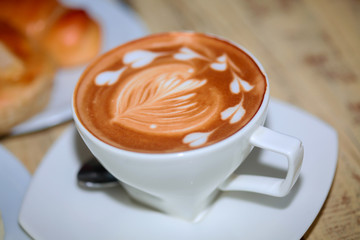 cups of cappuccino art on wooden table