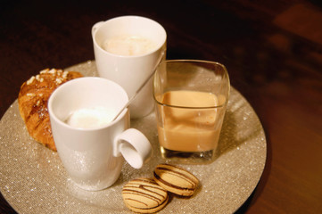 Cups of coffee and cookies on tray
