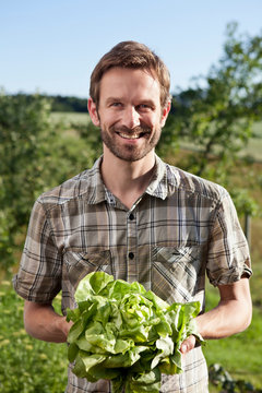 Man Holding Head Of Lettuce Outdoors