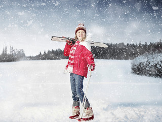 Girl carrying cross country skis in snow
