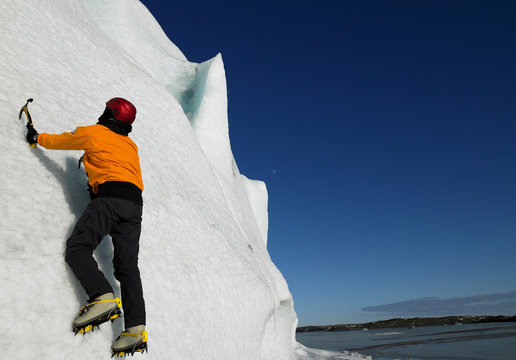 Man Climbing Glacier With Ice Pick